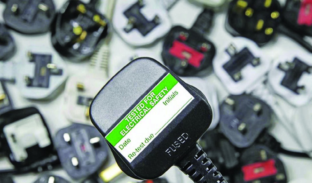 Portable appliance test instrument beside electrical equipment